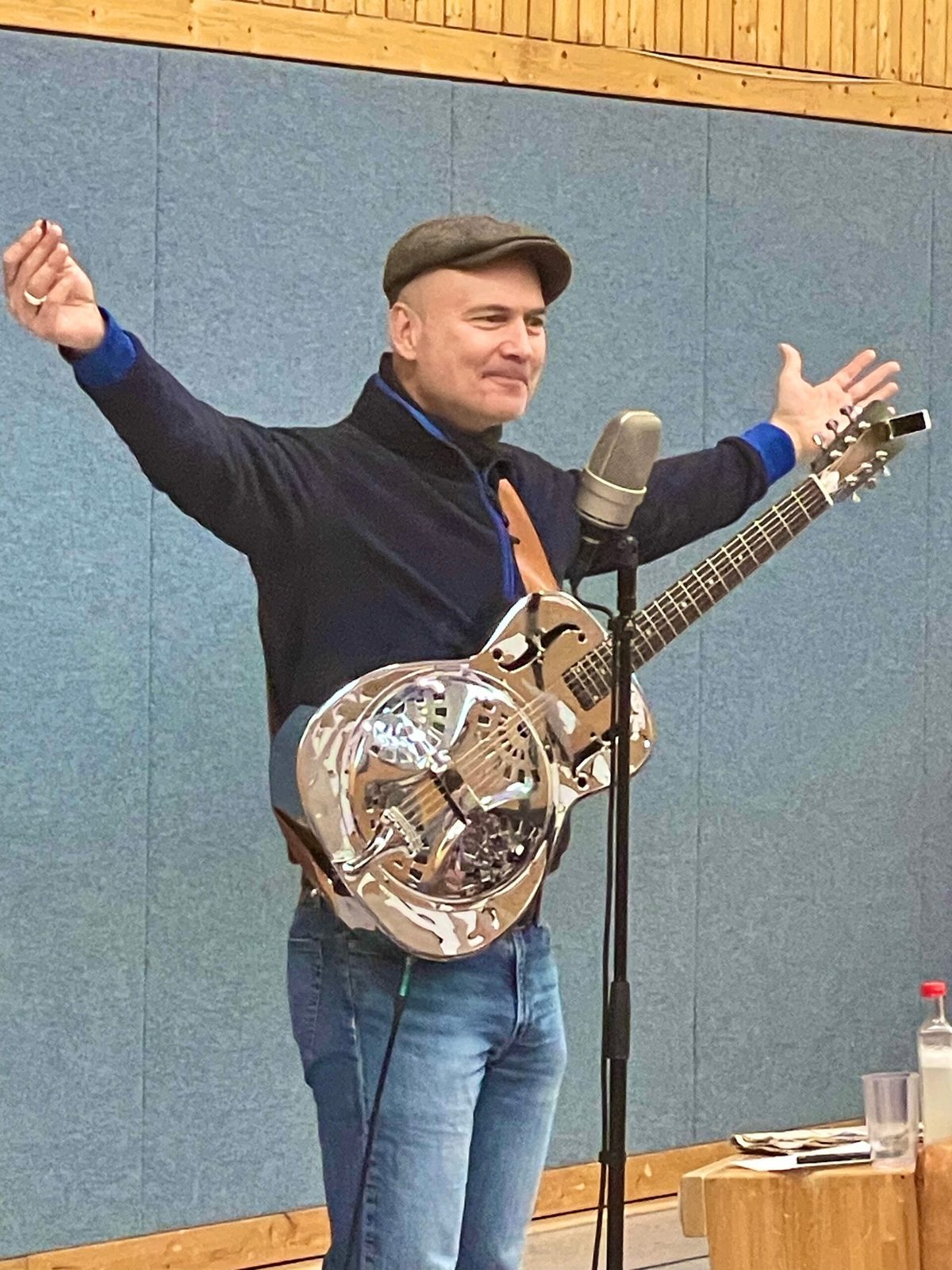 Musiker mit Resonator-Gitarre auf der Bühne in der Aula