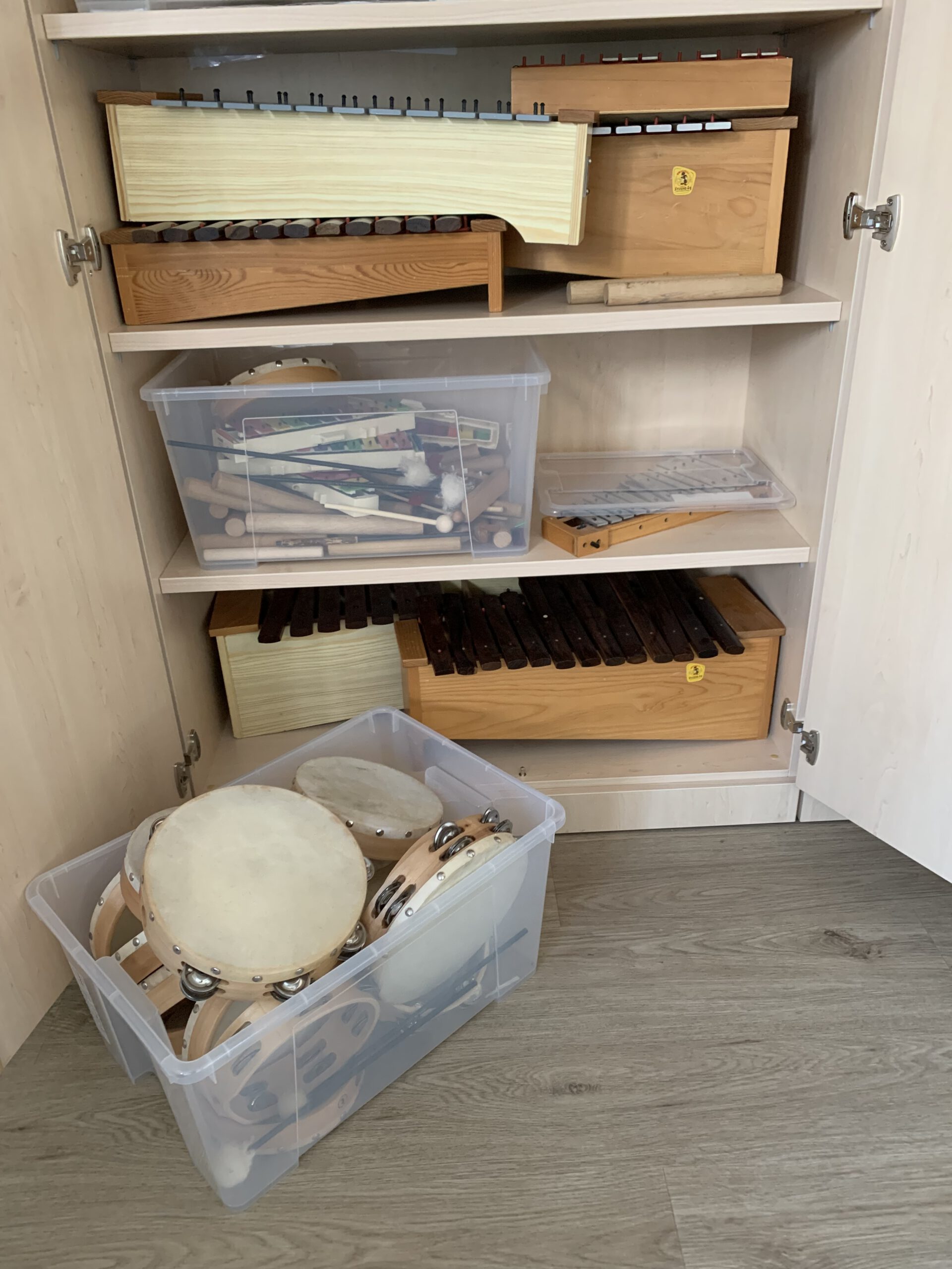 Schulinstrumente in einem Schrank: Trommeln, Xylophone, Tamburine